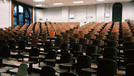 [Translate to Englisch:] Leere Stuhlreihen in einem Höhrsaal. 
